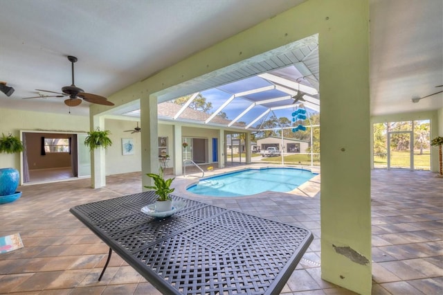 pool with glass enclosure, a ceiling fan, and a patio