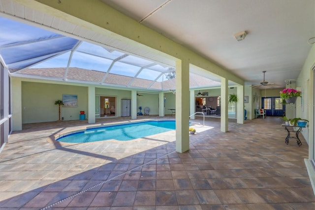 pool with ceiling fan, glass enclosure, and a patio