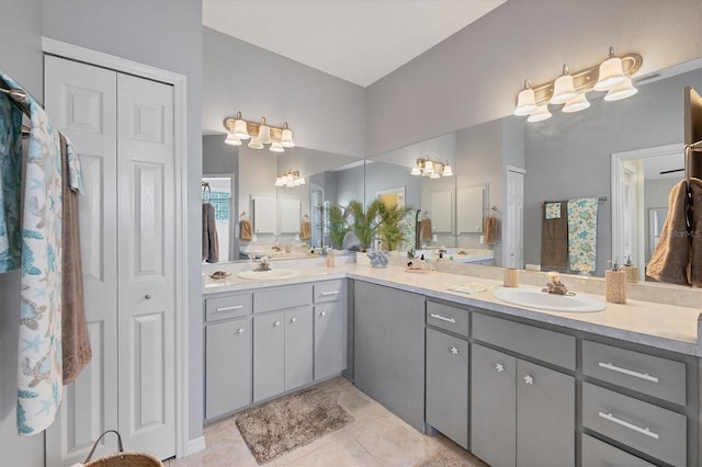 full bath with double vanity, a closet, a sink, and tile patterned floors