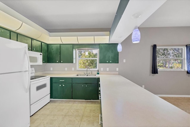 kitchen with white appliances, a sink, light countertops, pendant lighting, and green cabinetry