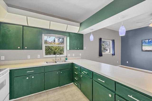 kitchen featuring green cabinets, light countertops, a sink, and pendant lighting