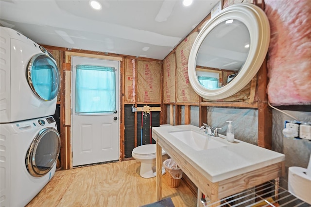 laundry room featuring stacked washer and dryer, a sink, and laundry area