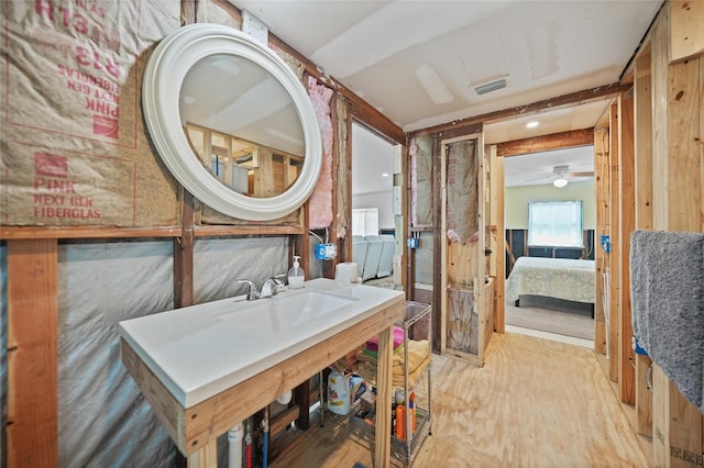 bathroom with ensuite bath, visible vents, and wood finished floors