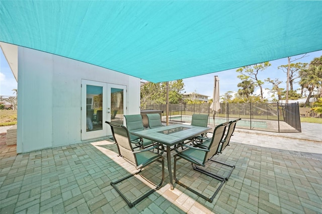 view of patio / terrace with a fenced in pool, french doors, fence, and outdoor dining area