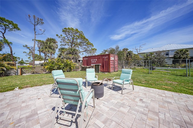 view of patio with an outbuilding, a storage shed, an outdoor fire pit, and a fenced backyard