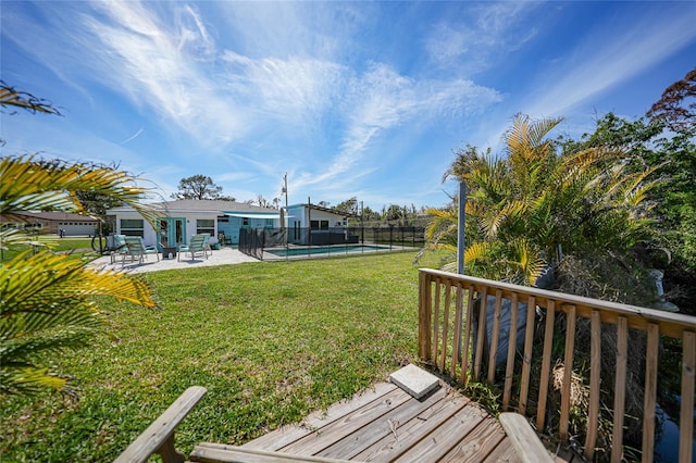 view of yard featuring fence, a deck, a fenced in pool, and a patio