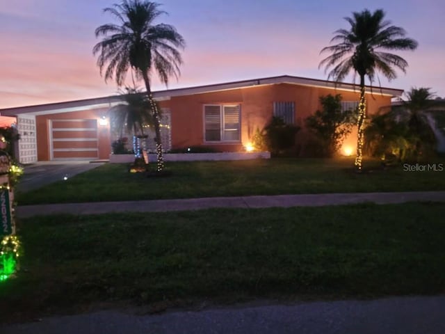 view of front of house featuring a garage, driveway, and a front yard