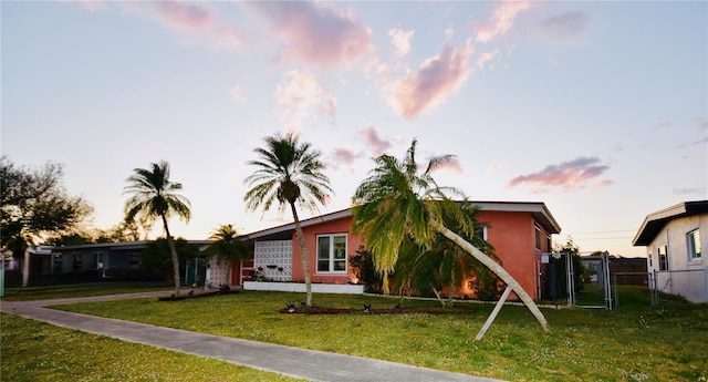 view of front of home with fence and a lawn