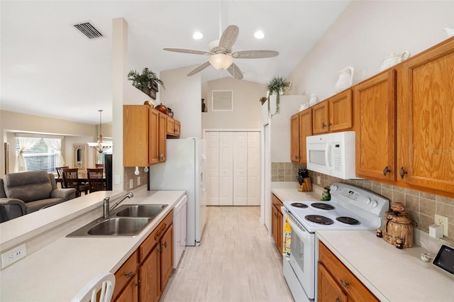 kitchen with white appliances, light countertops, visible vents, and a sink