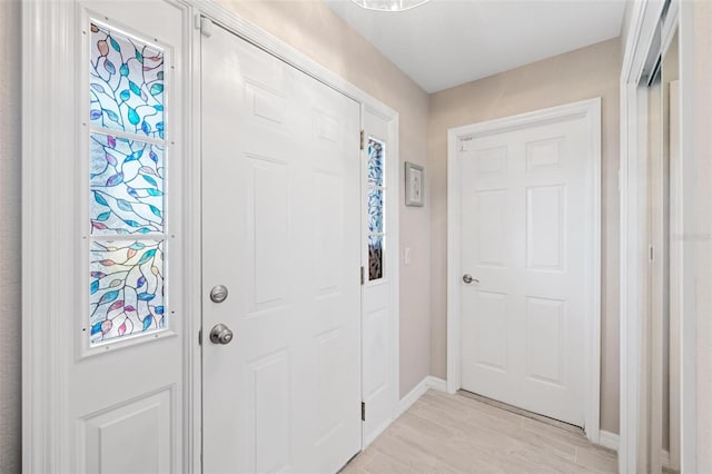 foyer featuring light wood-style floors and baseboards