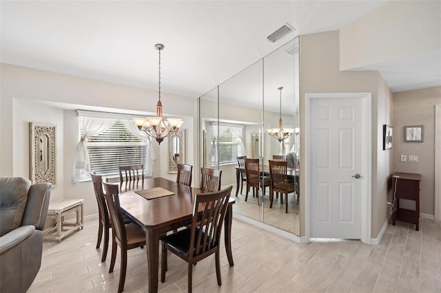 dining space with a notable chandelier, wood finish floors, baseboards, and visible vents