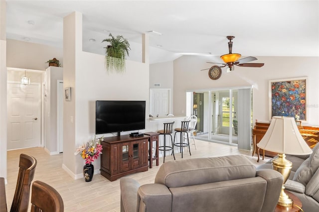 living area featuring visible vents, ceiling fan, baseboards, light wood-type flooring, and lofted ceiling