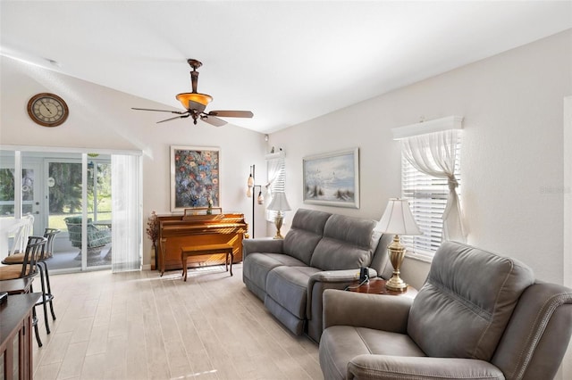 living area with light wood-style flooring, a ceiling fan, and lofted ceiling