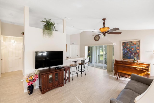 living room featuring lofted ceiling, light wood-style floors, and ceiling fan