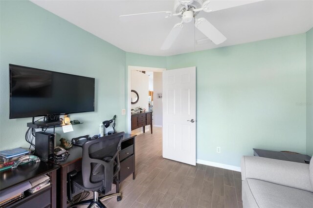 office area featuring wood finished floors, baseboards, and ceiling fan