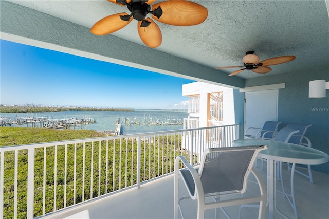 balcony featuring a water view and ceiling fan