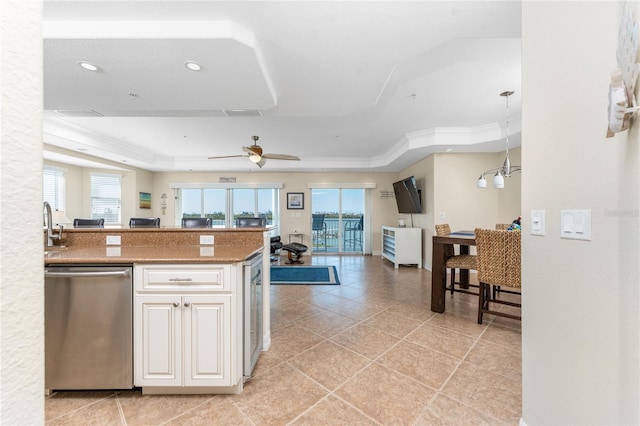 kitchen with ornamental molding, a raised ceiling, dishwasher, and light countertops