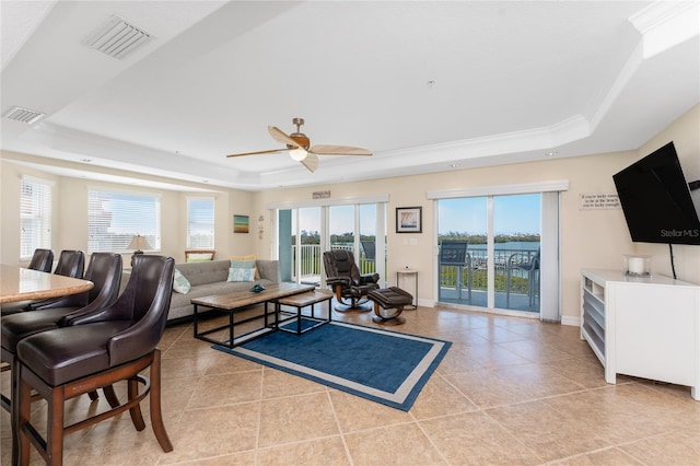 living area featuring light tile patterned floors, a tray ceiling, and visible vents