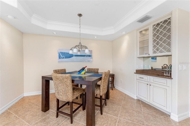 dining area with ornamental molding, a raised ceiling, visible vents, and baseboards