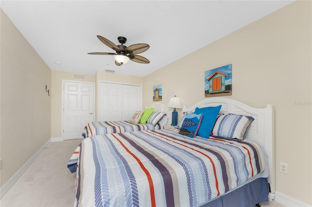 bedroom with a ceiling fan, a closet, light carpet, and baseboards