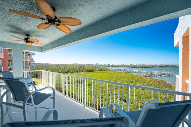 balcony featuring a water view and ceiling fan