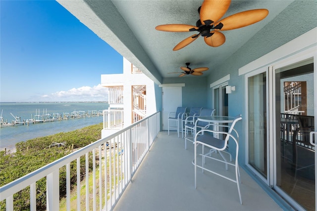 balcony with a water view and ceiling fan