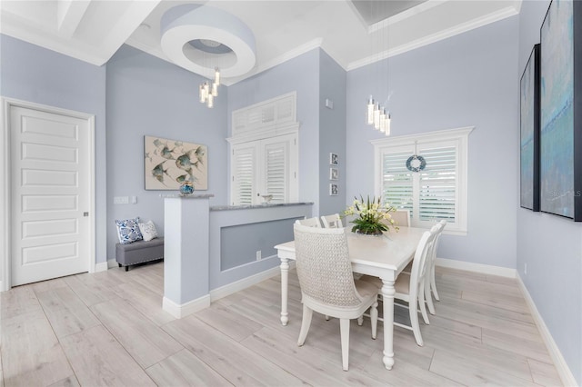 dining area featuring a chandelier, light wood-type flooring, ornamental molding, and baseboards