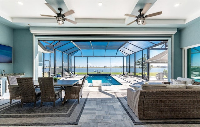 view of pool with a water view and a ceiling fan