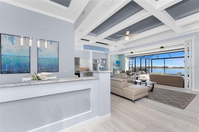 living room featuring a water view, coffered ceiling, a sunroom, visible vents, and light wood-type flooring