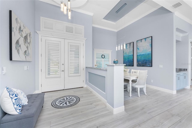 entryway with visible vents, baseboards, ornamental molding, wood tiled floor, and french doors