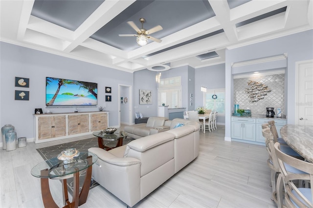 living area featuring beam ceiling, coffered ceiling, light wood-style flooring, and baseboards