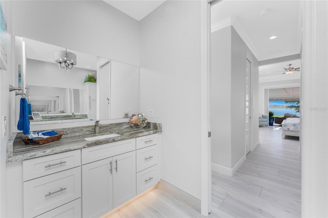 ensuite bathroom featuring ensuite bathroom, wood finished floors, vanity, and baseboards