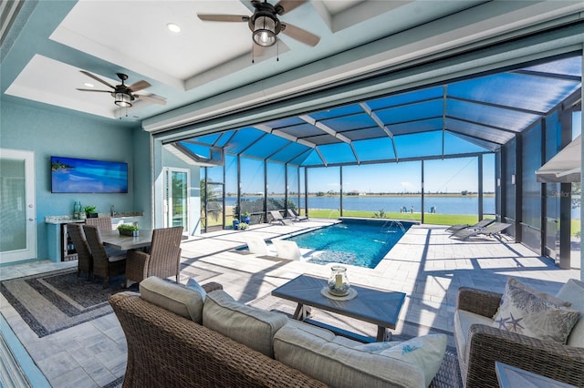 view of pool with a water view and a ceiling fan