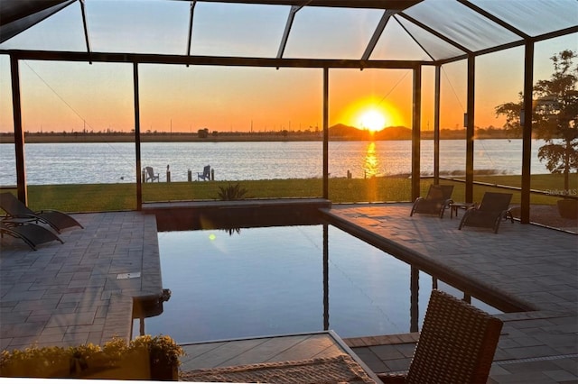 outdoor pool featuring a lanai, a patio area, and a water view