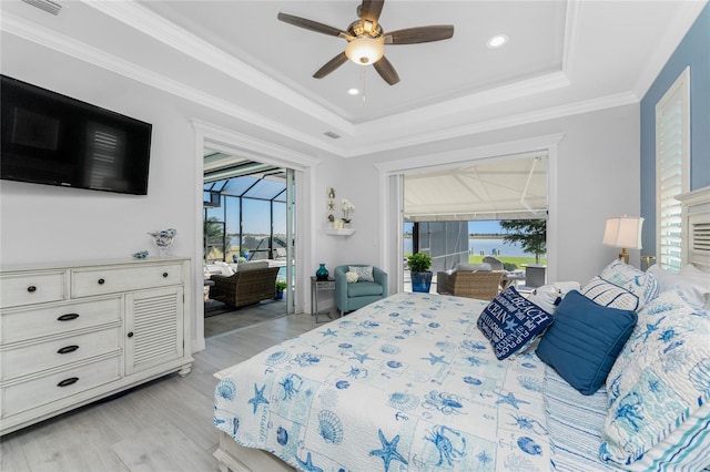 bedroom featuring a sunroom, access to exterior, light wood-type flooring, a tray ceiling, and crown molding