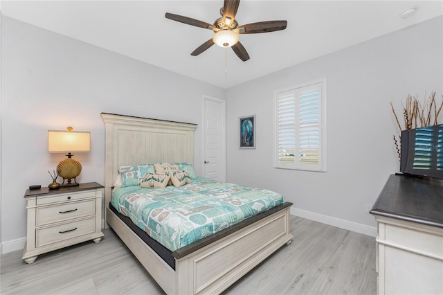 bedroom with light wood finished floors, ceiling fan, and baseboards