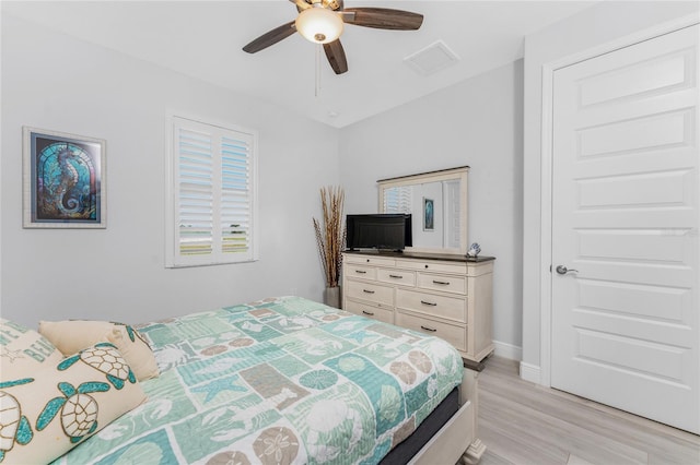 bedroom featuring baseboards, visible vents, ceiling fan, and light wood finished floors