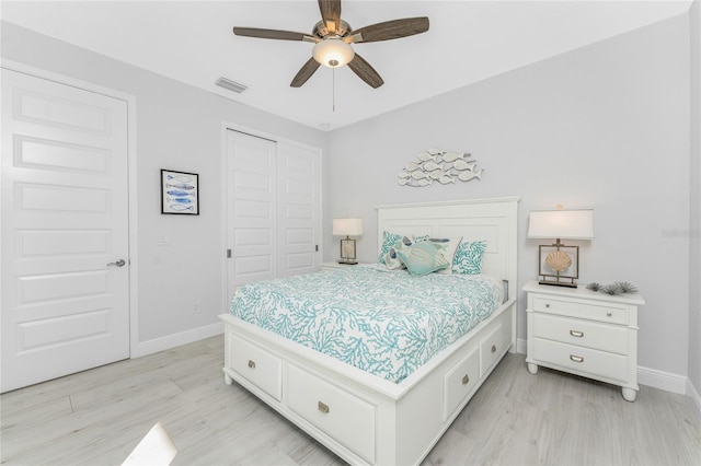 bedroom featuring light wood-style flooring, a closet, visible vents, and baseboards