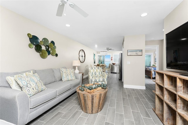 living area featuring ceiling fan, wood finish floors, and baseboards