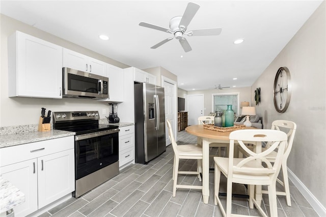 kitchen with baseboards, stainless steel appliances, white cabinetry, and recessed lighting