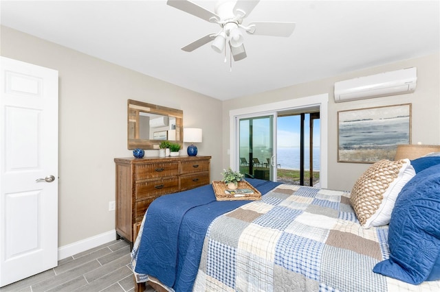 bedroom featuring baseboards, a ceiling fan, a wall unit AC, access to outside, and wood finish floors