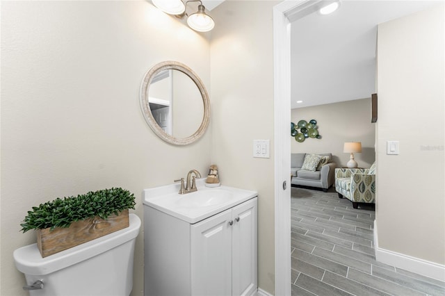 ensuite bathroom featuring toilet, wood finish floors, ensuite bath, and vanity