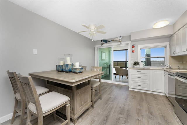 kitchen with stainless steel appliances, white cabinetry, a ceiling fan, light countertops, and light wood finished floors