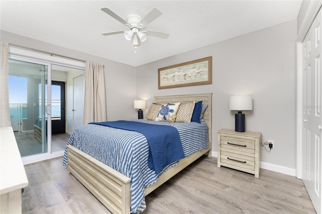 bedroom featuring a textured ceiling, wood finished floors, and baseboards