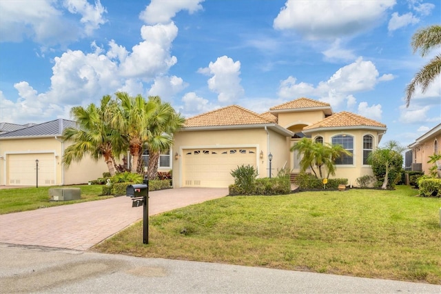 mediterranean / spanish-style house featuring driveway, an attached garage, a front lawn, and stucco siding