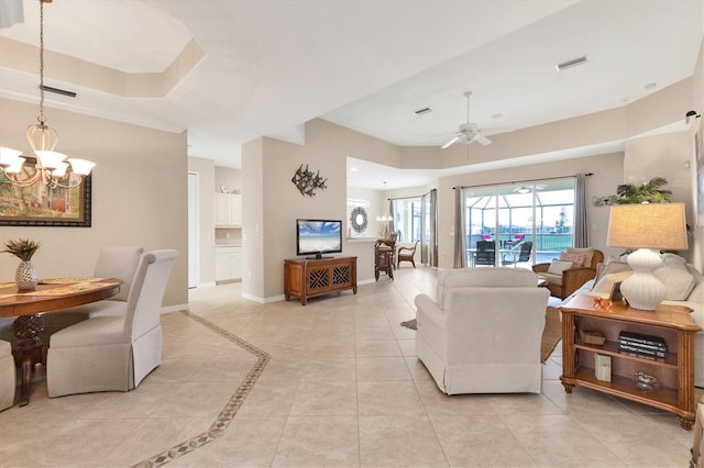 living room with a raised ceiling, visible vents, baseboards, and ceiling fan with notable chandelier