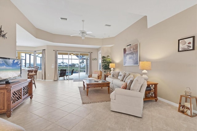 living room featuring baseboards, visible vents, a ceiling fan, and light tile patterned flooring