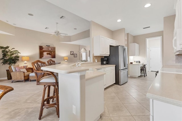 kitchen with open floor plan, light countertops, a peninsula, and white cabinetry