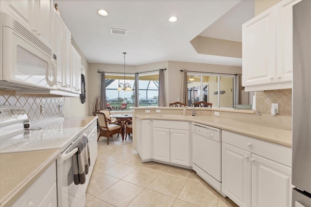 kitchen with light countertops, white appliances, decorative light fixtures, and white cabinetry