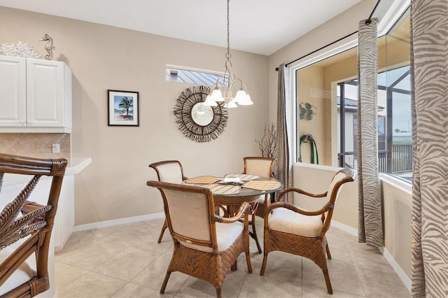 dining room with a chandelier, light tile patterned floors, and baseboards